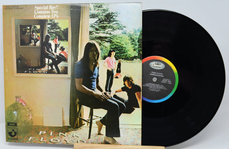 Vinyl record with cover featuring Pink Floyd album art on a white background