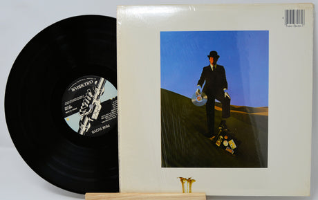 Vinyl record with a cover featuring a person in a suit on a hillside.