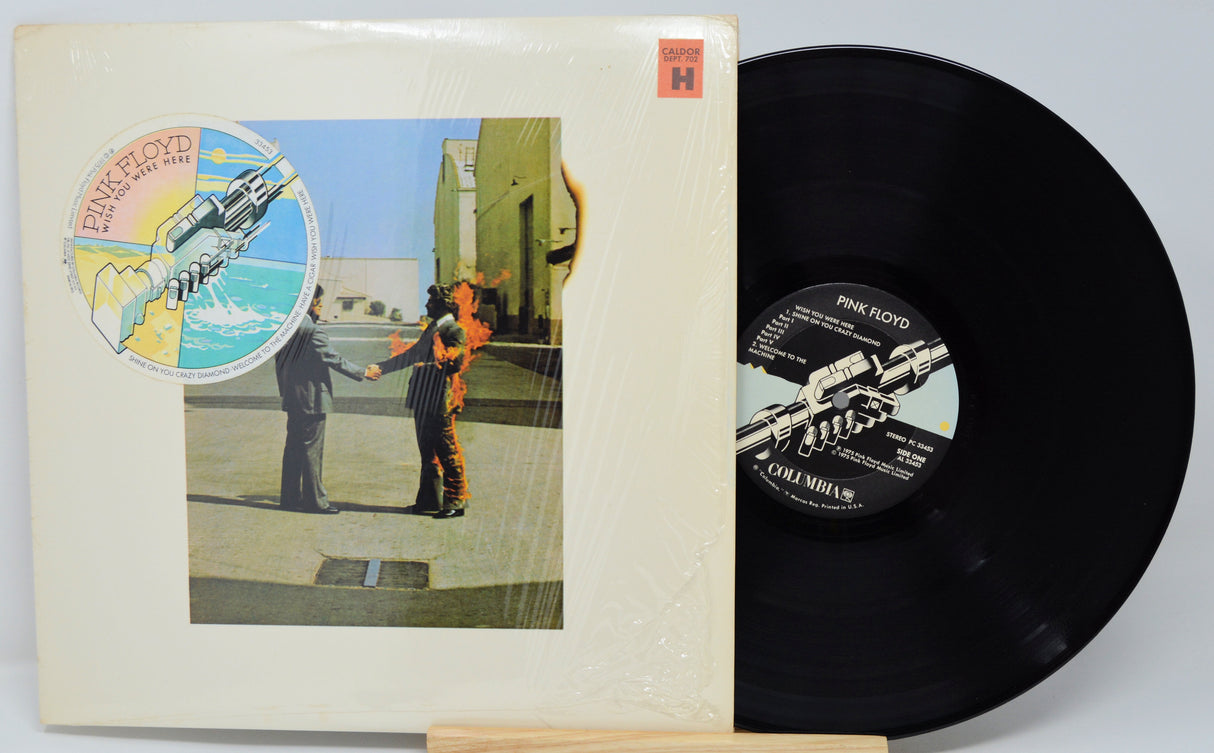 Vinyl record and cover with artwork of two figures holding hands and a spaceship.