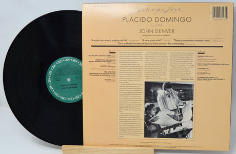 Vinyl record with a black cover and a yellowed sleeve featuring text and a photo of two people.