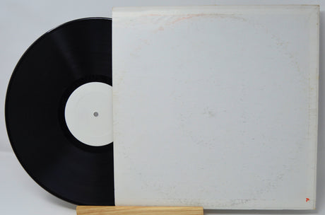 Vintage vinyl record with blank white label and plain white sleeve, partially shown.