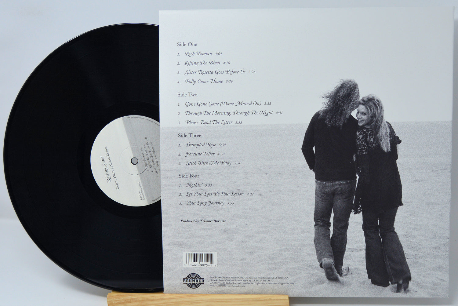 Vinyl record LP shown with the back cover insert, featuring a black record partially covering the sleeve and a printed tracklist and couple photograph on the cover.