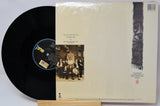 Vinyl record with a black disc and a cover featuring a group of people and a decorative pattern.