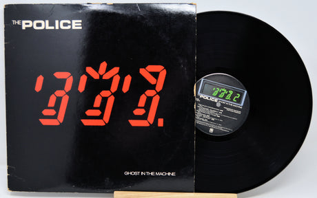 The Police 'Ghost in the Machine' vinyl record LP with its black cover featuring a red digital clock display, shown next to the black record on a light gray background.