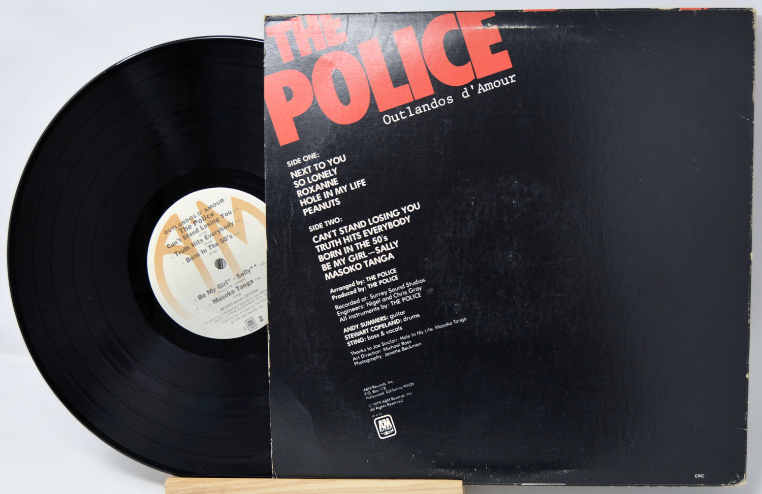 Vinyl record with cover featuring 'The Police' and album title on a light gray background