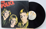 Vinyl record and cover of 'The Police' album 'Outlandos d'Amour' on a light gray background
