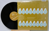 Vinyl record with a yellow cover featuring blue geometric patterns on a light gray background