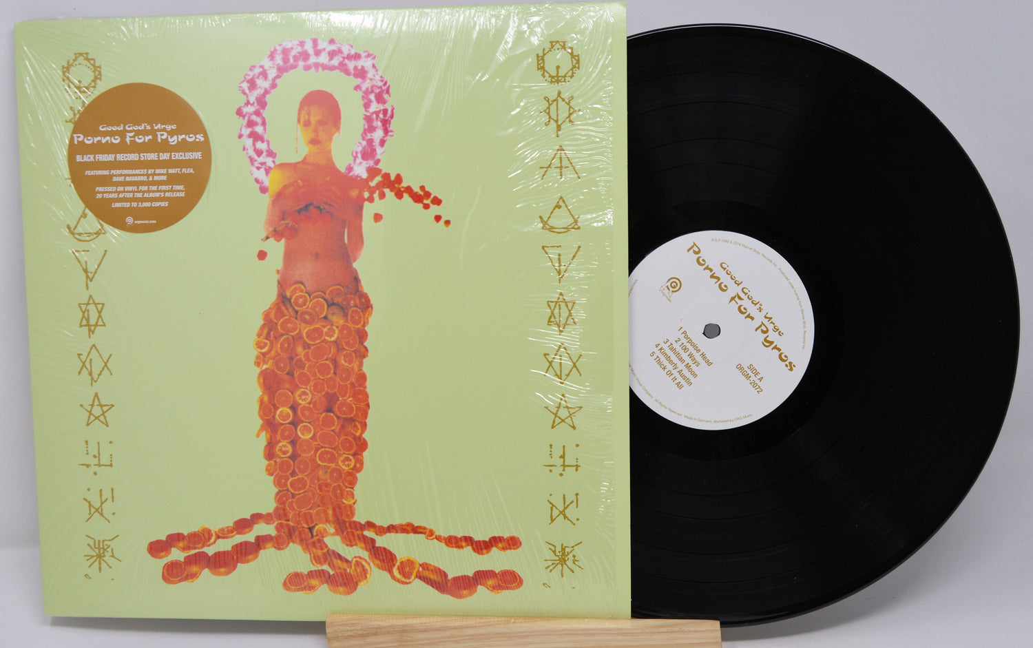 Vinyl record with a colorful cover featuring a stylized figure on a light gray background