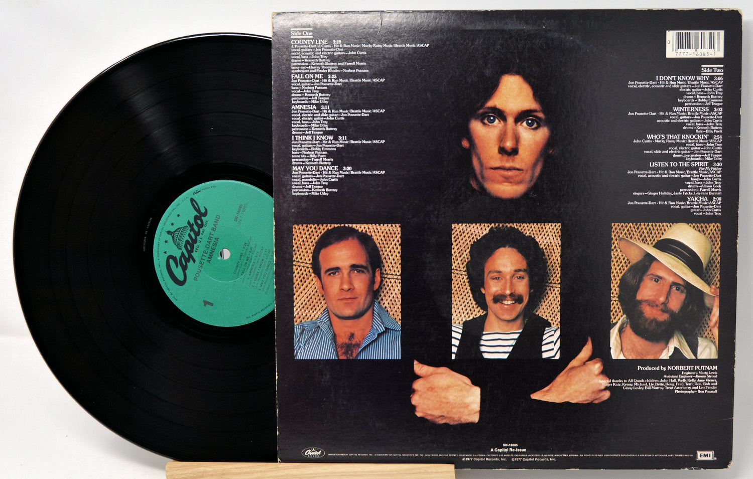 Vinyl record with a black cover featuring portraits of a person and text.