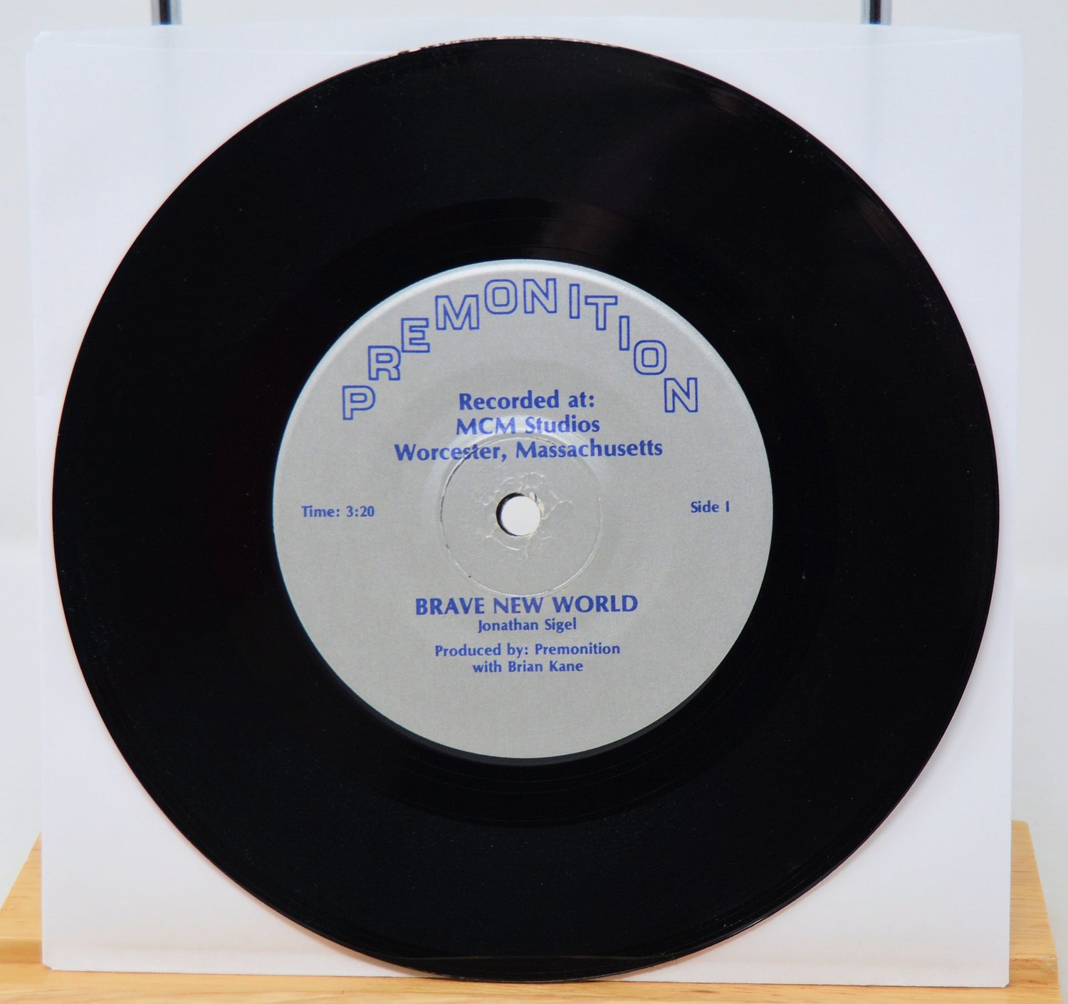 Vinyl record with a white label on a white background featuring Brand New World 