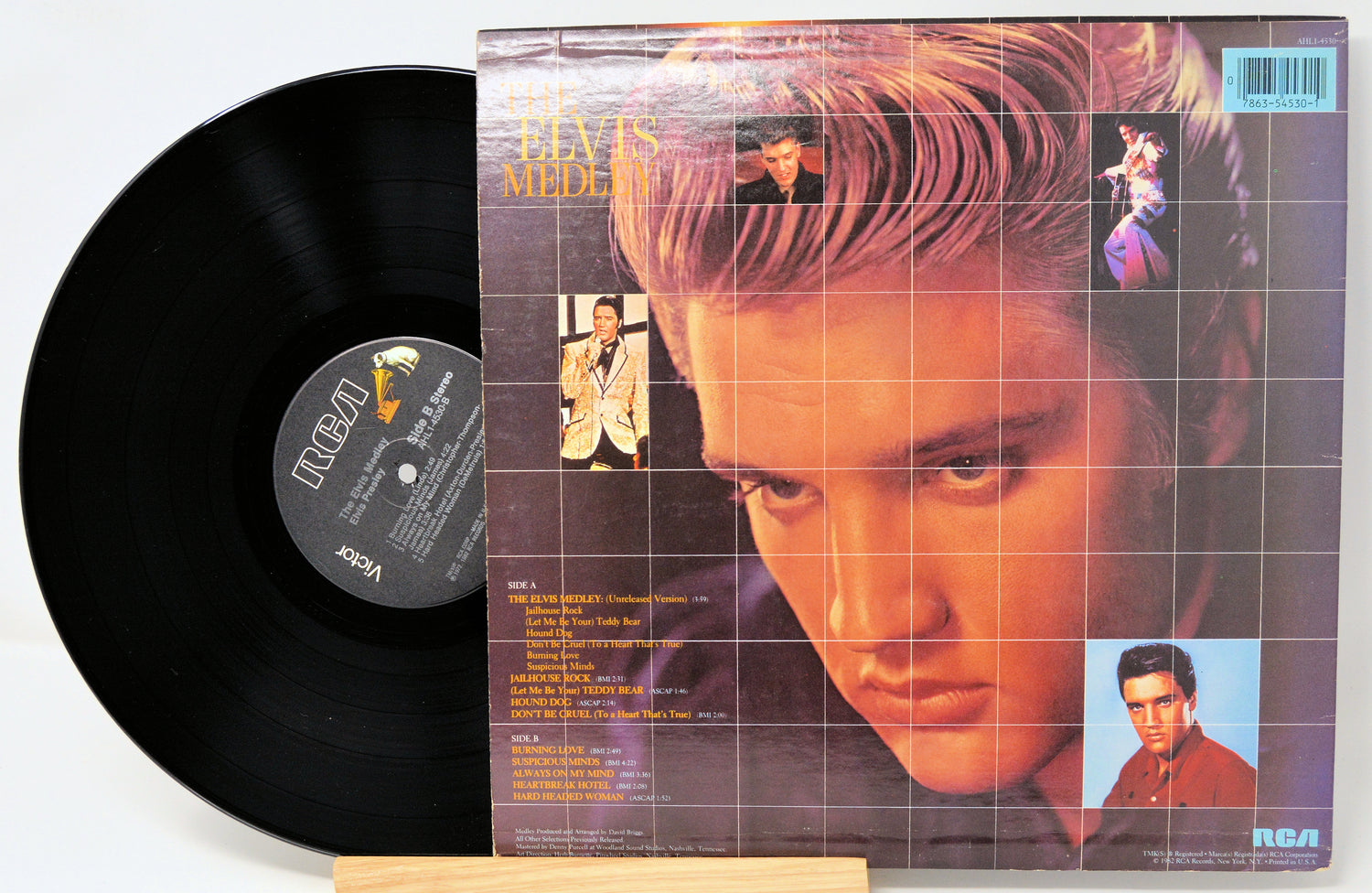 Vinyl record with cover featuring a grid pattern and images of a person, on a white background.