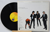 Vinyl record with a cover featuring four people and a yellow label.