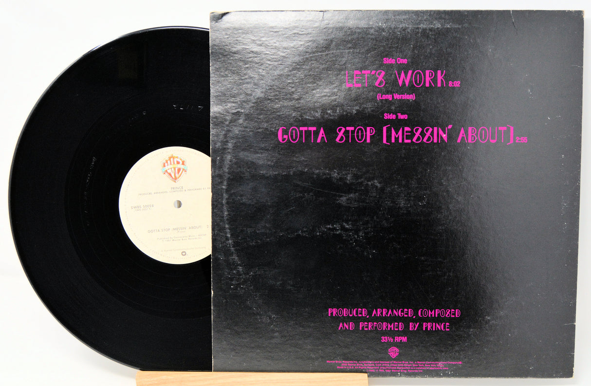 Vinyl record with a black label and a cover featuring pink text on a white background