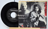 Vinyl record and its cover featuring a black and white portrait of a woman and a man.