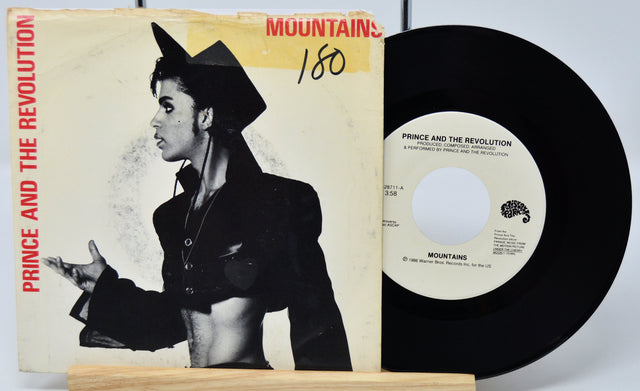 Vinyl record and cover of 'Mountains' by Prince and the Revolution on a white background