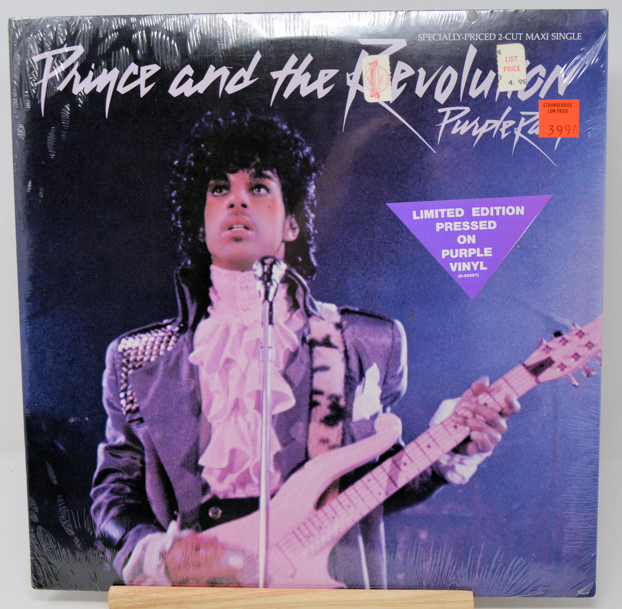 Vinyl record cover with a portrait of a person on one side and a list of songs on the other, featuring a yellow and black color scheme.