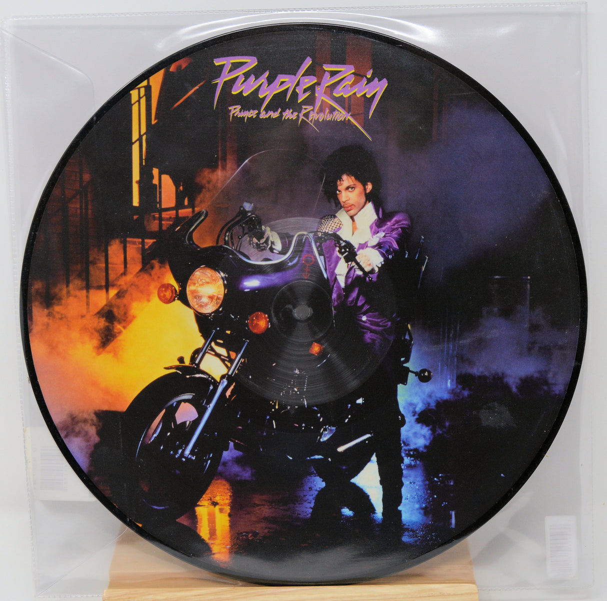 Vinyl record with a cover featuring a person on a motorcycle and 'Purple Rain' text.