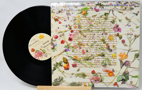 Vinyl record with a colorful floral and text design on the cover