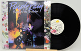 Vinyl record and cover for 'Purple Rain' by Prince and the Revolution on a white background.