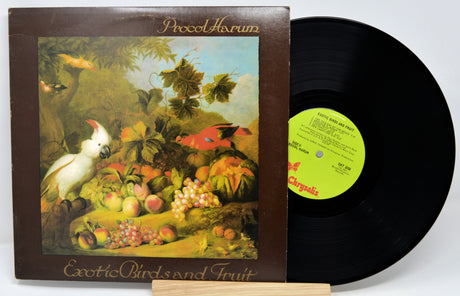 Vinyl record with a colorful cover featuring birds and fruit, on a white background.