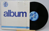 Vinyl record with cover featuring 'PIL' logo on a white background