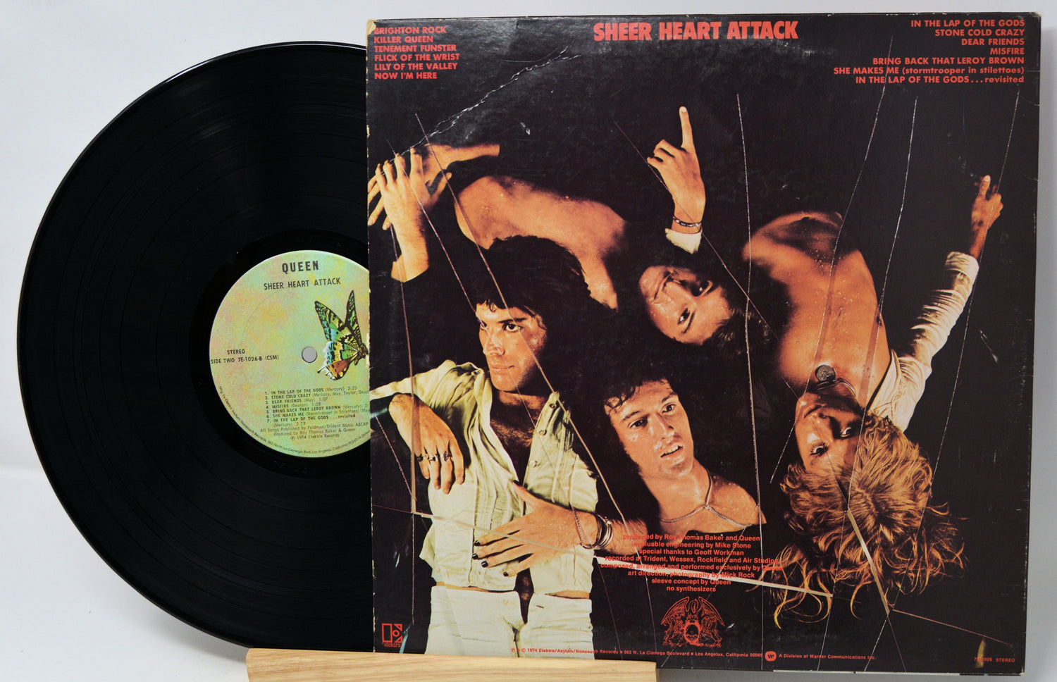 Vinyl record and cover of 'Sheen Heart Attack' by Queen on a light gray background