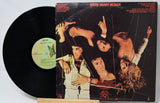 Vinyl record and cover of 'Sheen Heart Attack' by Queen on a light gray background
