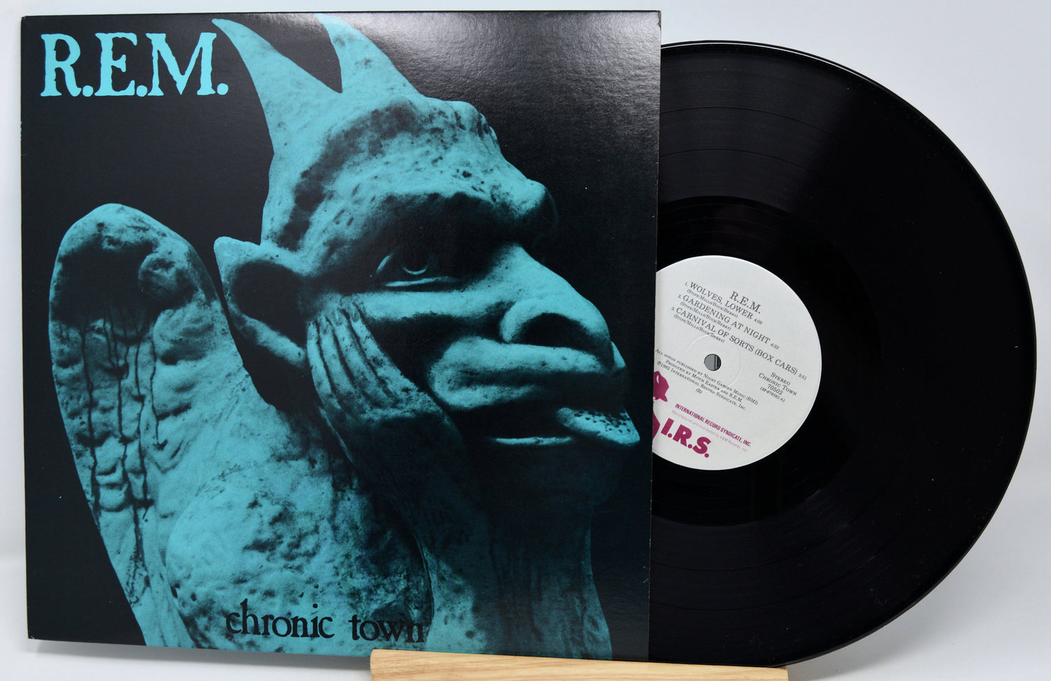 Vinyl record with a cover featuring a stylized face and 'R.E.M.' branding.
