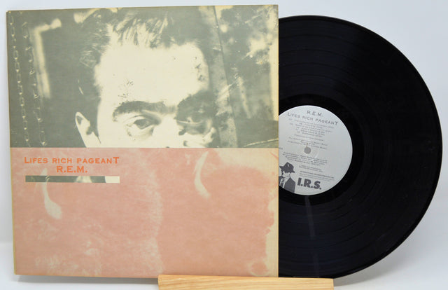 Used vinyl record of R.E.M. - Life's Rich Pageant with the album cover and a vinyl record displayed in front of it.
