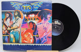 Vinyl record with colorful cover featuring band members and 'REO' branding.