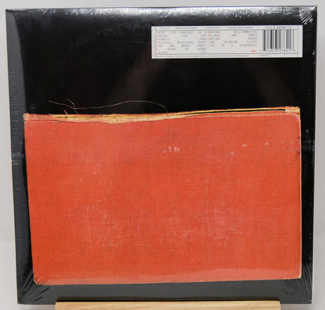 A square canvas print featuring a textured orange-red rectangle against a black background, wrapped in protective plastic with a barcode sticker at the top right.