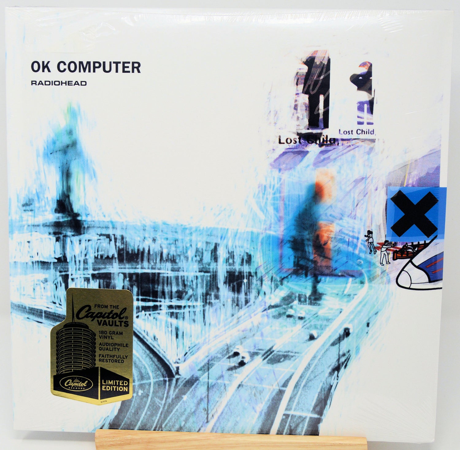 Radiohead's 'OK Computer' 12-inch vinyl record, Limited Edition with a gold Crested Vaults seal, shown on a wooden display stand.