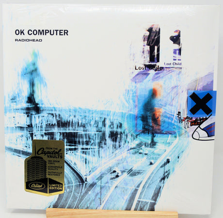 Radiohead's 'OK Computer' 12-inch vinyl record, Limited Edition with a gold Crested Vaults seal, shown on a wooden display stand.