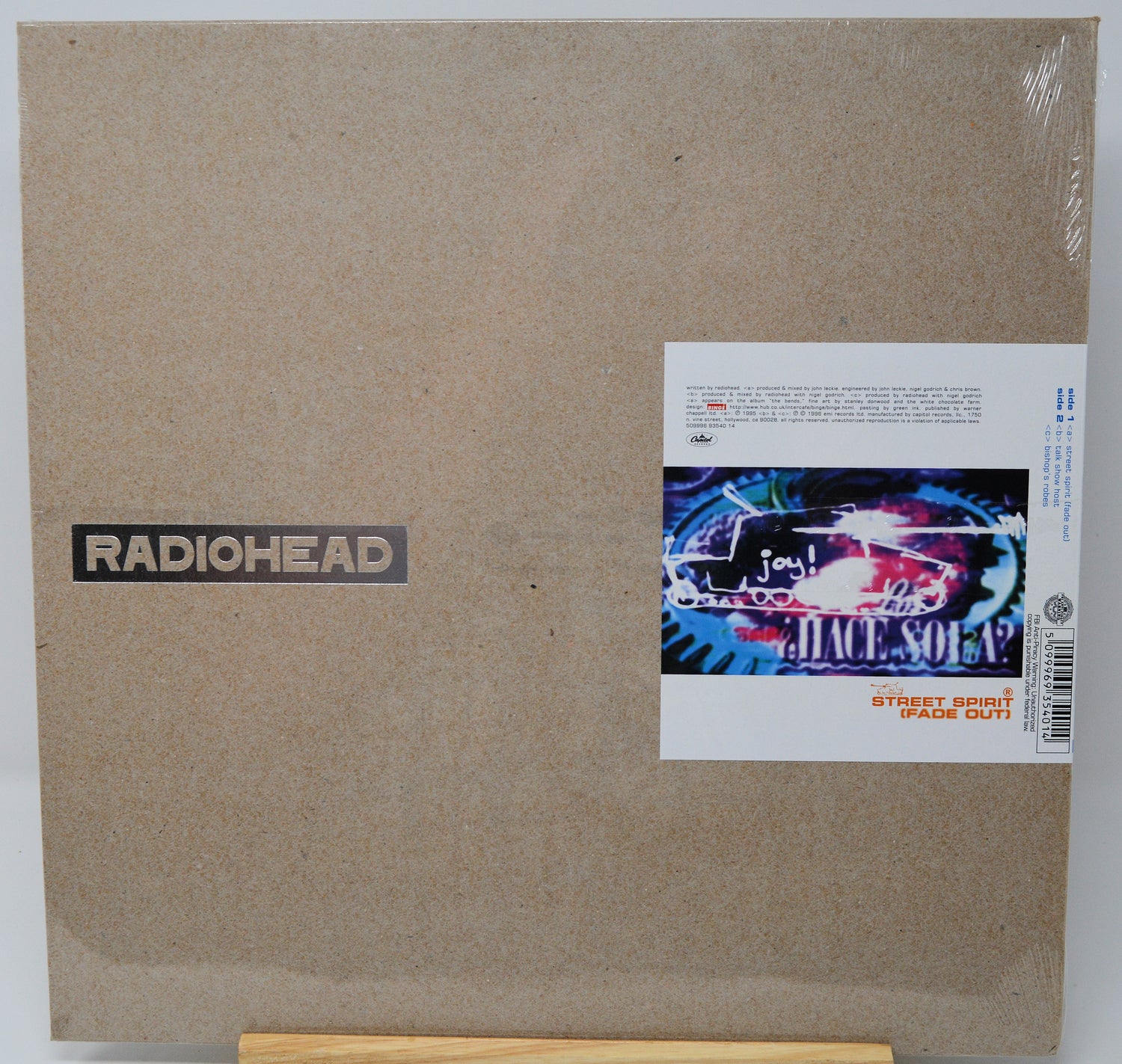 Radiohead 'Soleil' vinyl record album cover in its shrink wrap, displayed on a wooden stand against a white background.