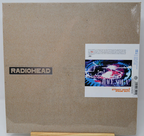 Radiohead 'Soleil' vinyl record album cover in its shrink wrap, displayed on a wooden stand against a white background.