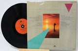 Vinyl record with a colorful album cover featuring a sunset and geometric shapes.
