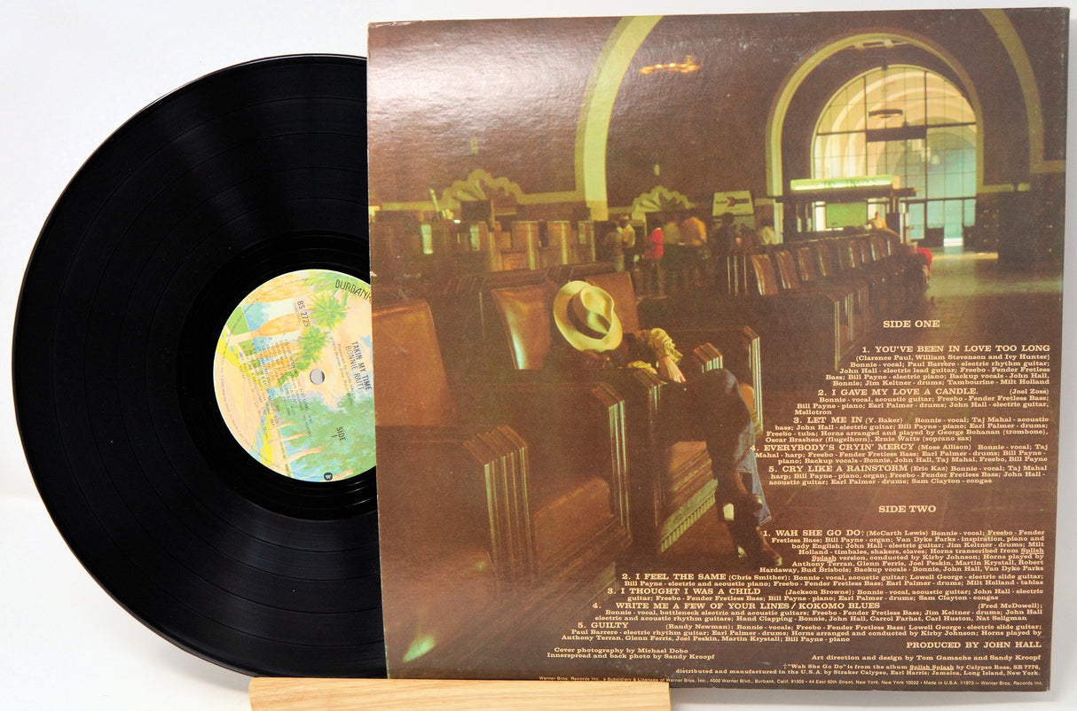 Vinyl record with cover showing a person in a hat sitting in an airport lounge.