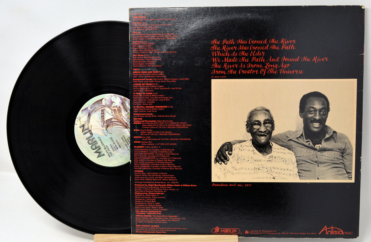 Vinyl record with a black and white cover featuring a group of people and a desert landscape.