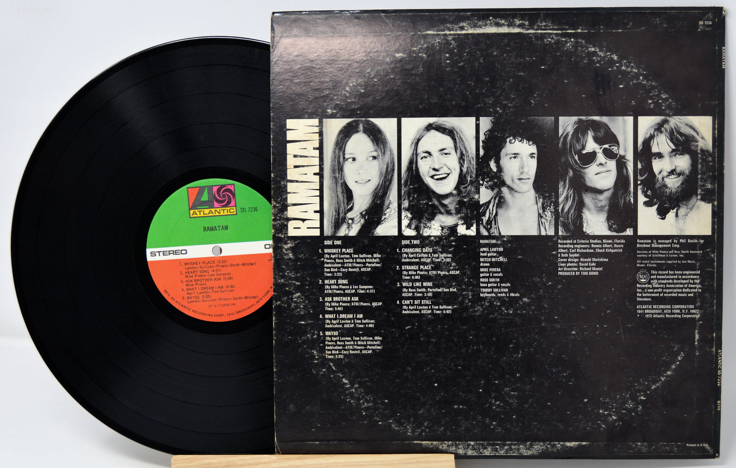 Vinyl record with cover featuring band members' portraits on a white background