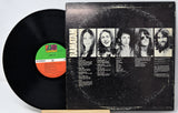 Vinyl record with cover featuring band members' portraits on a white background