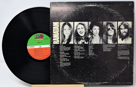 Vinyl record with cover featuring band members' portraits on a white background