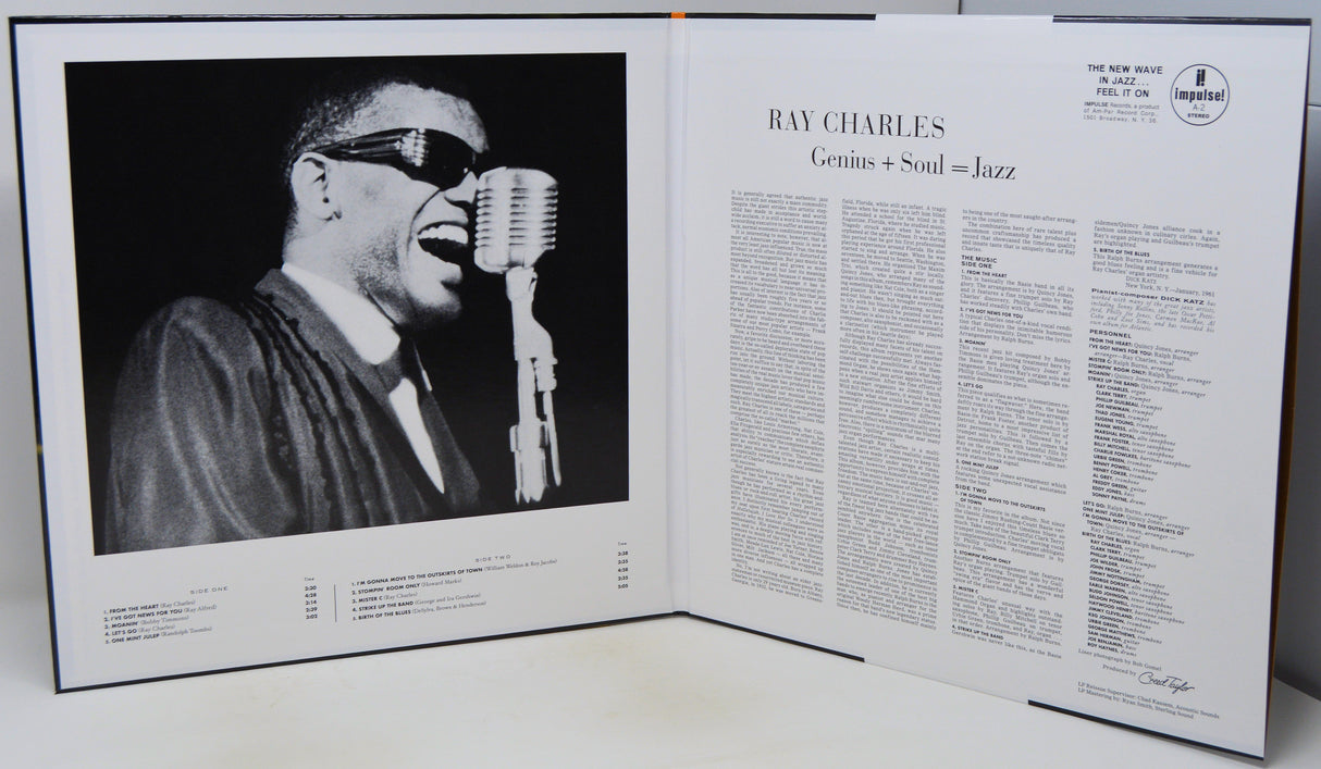 An open book or magazine spread showing a black-and-white photograph of Ray Charles singing into a microphone on the left page, with article text about Ray Charles on the right page.