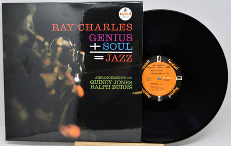 Ray Charles 'Genius + Soul = Jazz' vinyl record album with the black LP disc partially pulled from the sleeve, photographed on a light gray background.