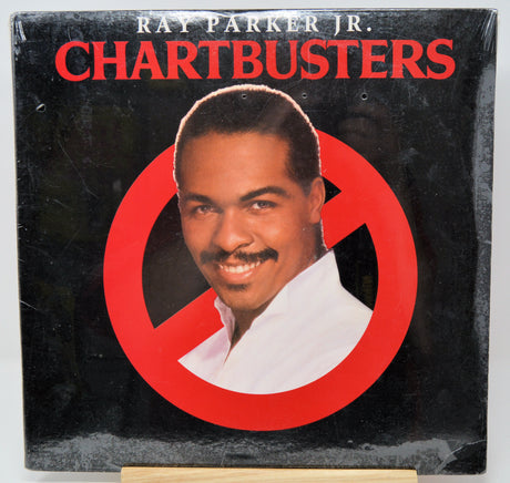 Album cover of 'Chartbusters' by Ray Parker Jr. with a portrait of the artist on a black background with red circle and line.