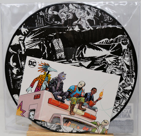 Vinyl record with a black and white cover featuring cartoon characters and a colorful cover with people on a truck.