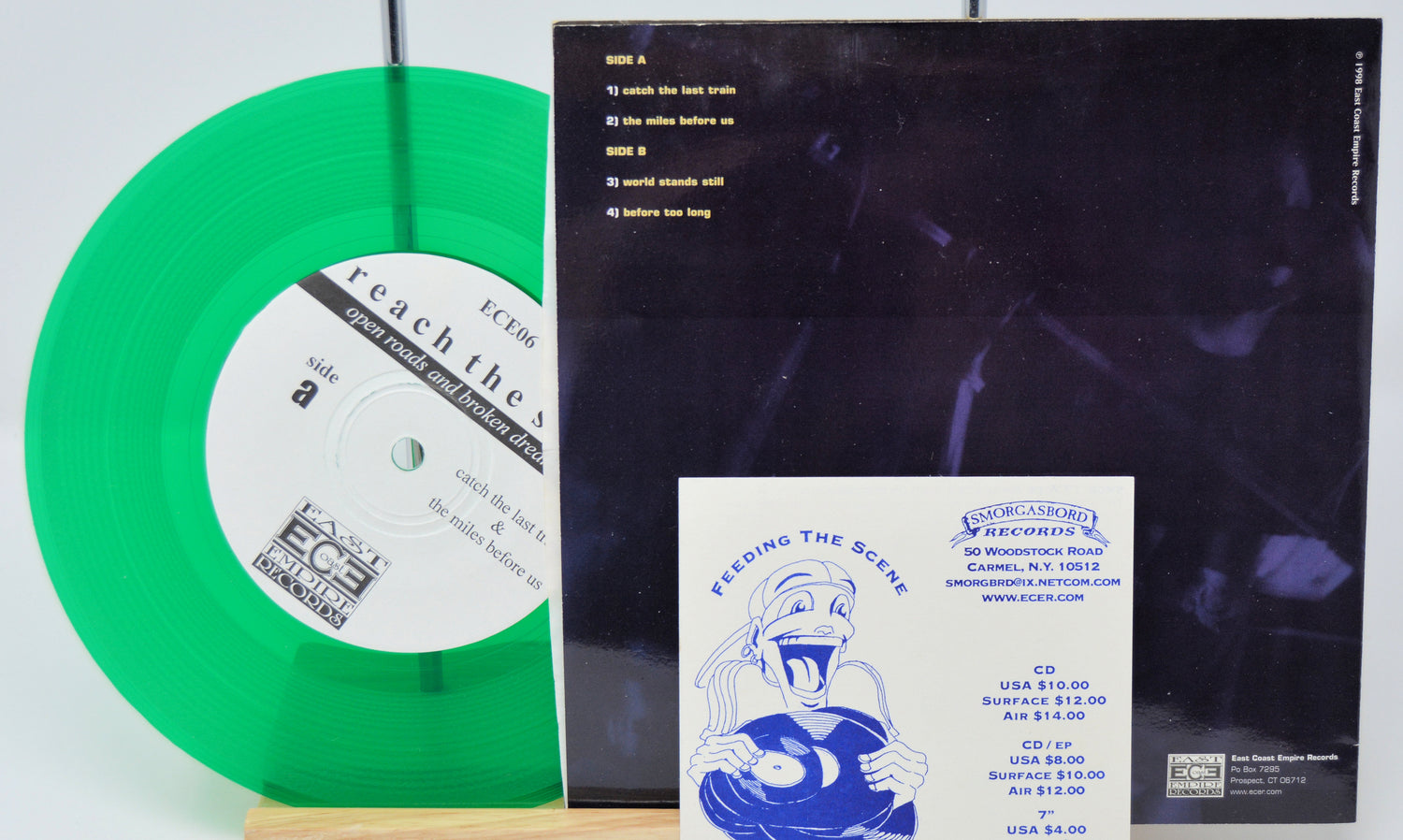 Green vinyl record with a black cover and blue and white flyer on a white background