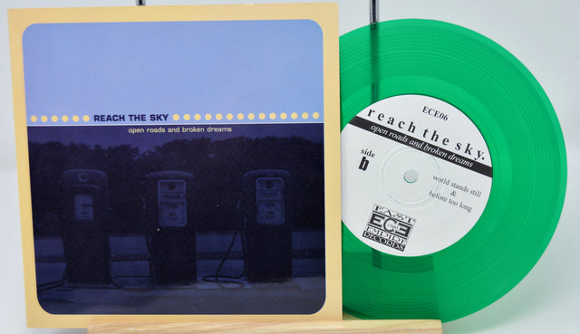 Vinyl record with green disc and cover featuring 'Reach the Sky' on a white background