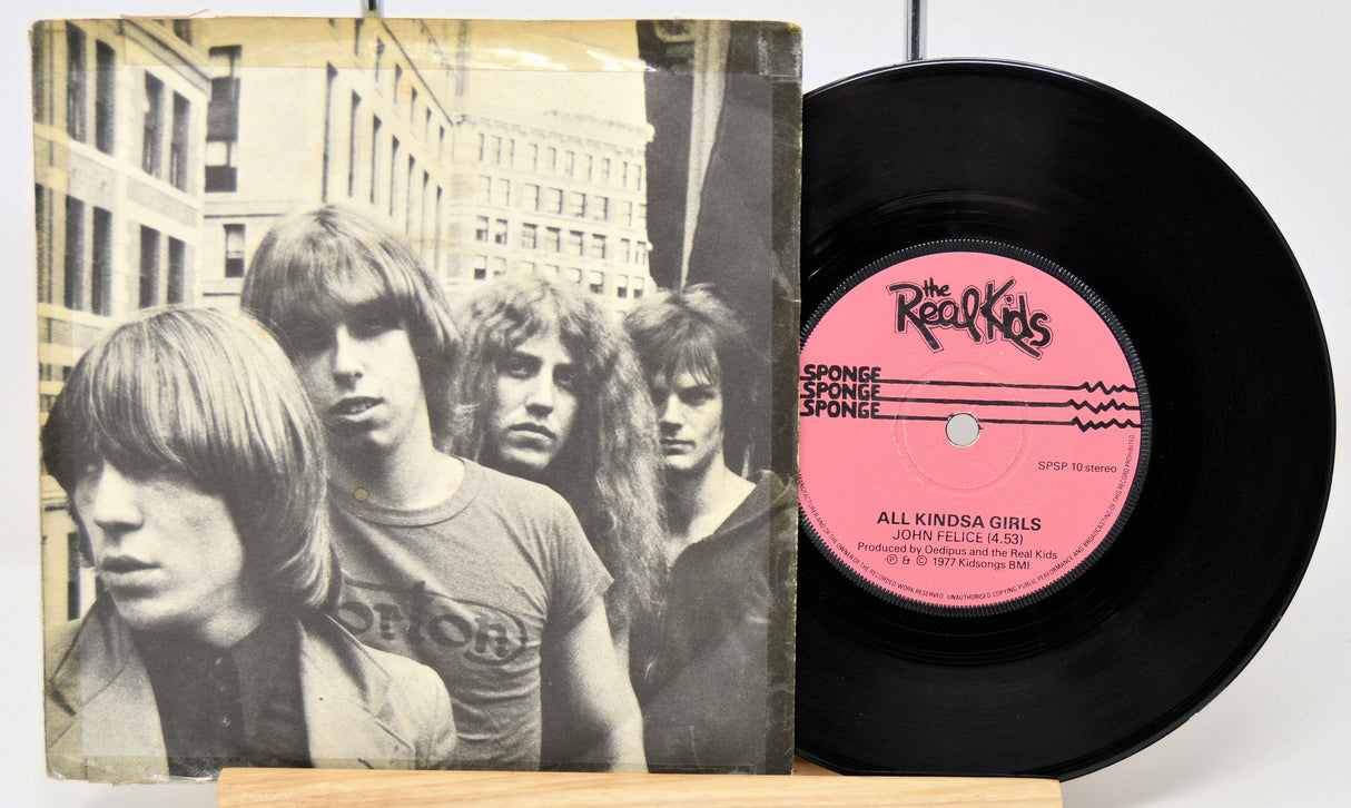 Vinyl record with a pink label featuring a band portrait on the cover