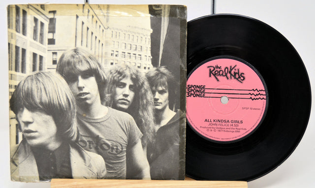 Vinyl record with a pink label featuring a band portrait on the cover