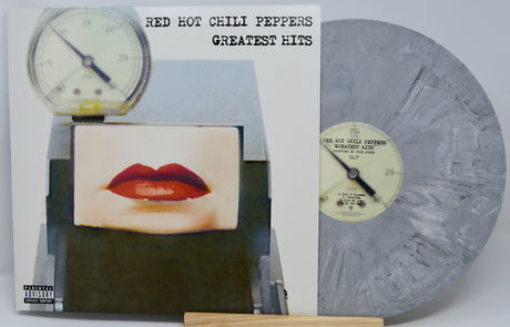 Red Hot Chili Peppers Greatest Hits vinyl record album shown with the printed cover on the left and a marbled gray-blue vinyl record on the right, displayed upright on a small wooden stand.